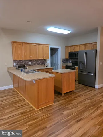 a kitchen with stainless steel appliances granite countertop a stove top oven a sink dishwasher and a refrigerator