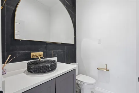 a bathroom with a sink a toilet and mirror