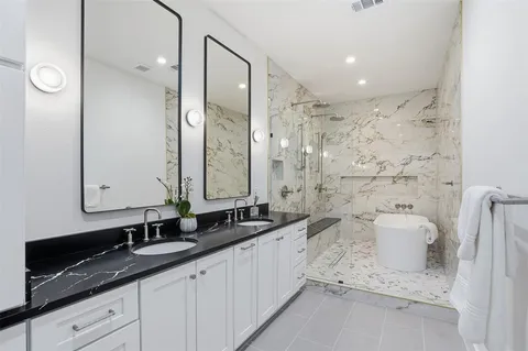 a bathroom with a double vanity sink mirror double and shower