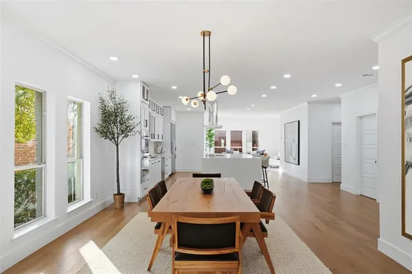 a view of a dining room and livingroom with furniture wooden floor a chandelier