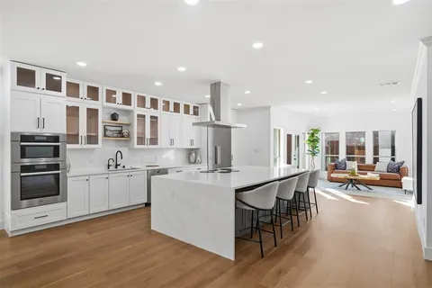 a kitchen with stainless steel appliances kitchen island granite countertop a stove and a refrigerator