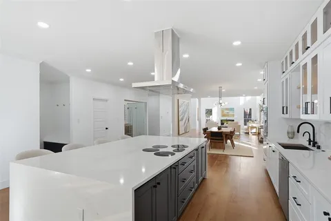 a large white kitchen with a large window