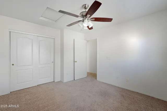 an empty room with a ceiling fan and a window