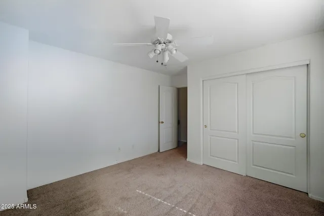 an empty room with chandelier fan