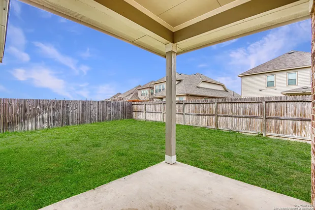a view of a backyard with wooden fence