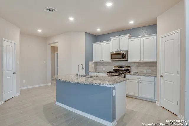 a kitchen with stainless steel appliances granite countertop a stove a sink and a refrigerator