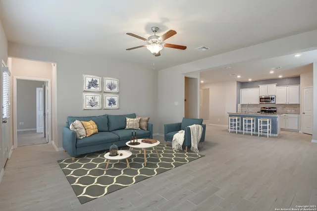 a living room with furniture and a dining table with projector