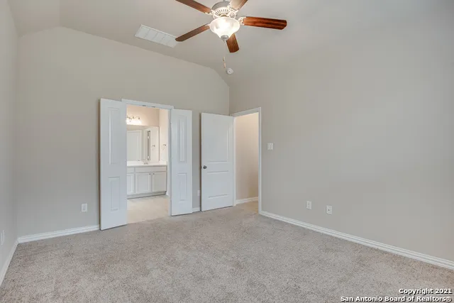 a view of an empty room and chandelier fan