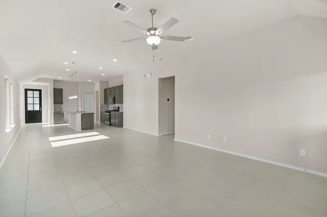 a view of an empty room with a kitchen