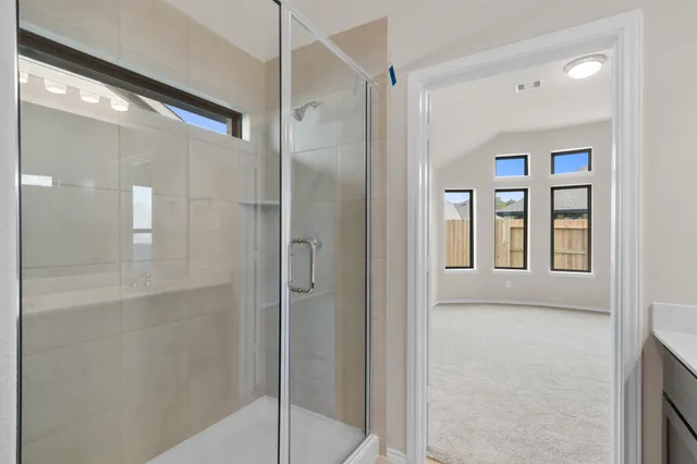 a bathroom with a shower and a glass door