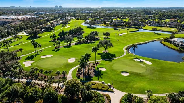 an aerial view of a residential houses with outdoor space and trees