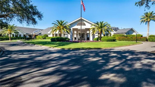 a front view of a house with a yard and palm trees
