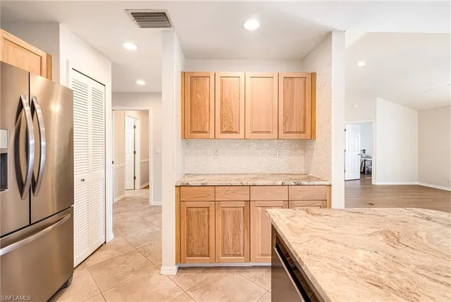 a kitchen with stainless steel appliances granite countertop a refrigerator and a sink