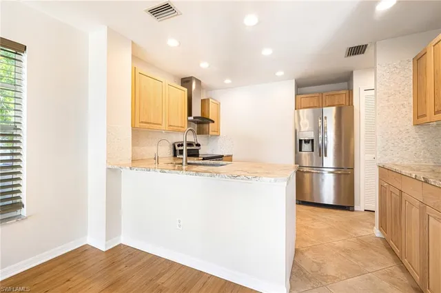 a kitchen with stainless steel appliances a refrigerator and a stove top oven
