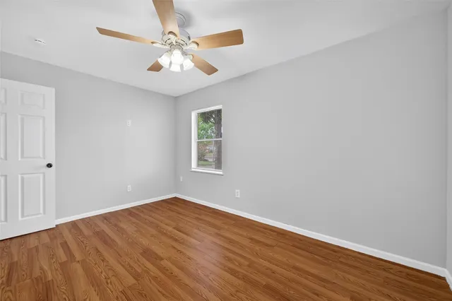 a view of an empty room with wooden floor