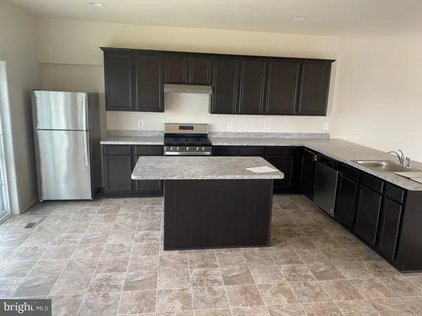 a kitchen with stainless steel appliances granite countertop a stove a refrigerator and a sink