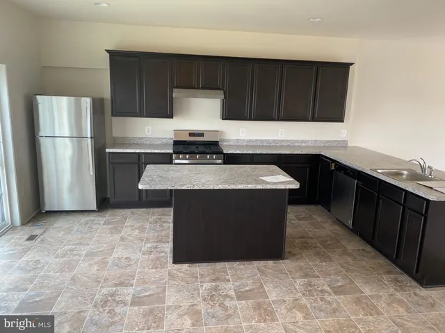 a kitchen with stainless steel appliances granite countertop a stove a refrigerator and a sink