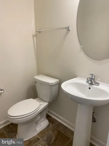 a white toilet sitting next to a bathroom sink