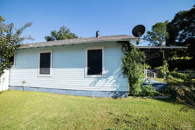 a view of a house with backyard and sitting area