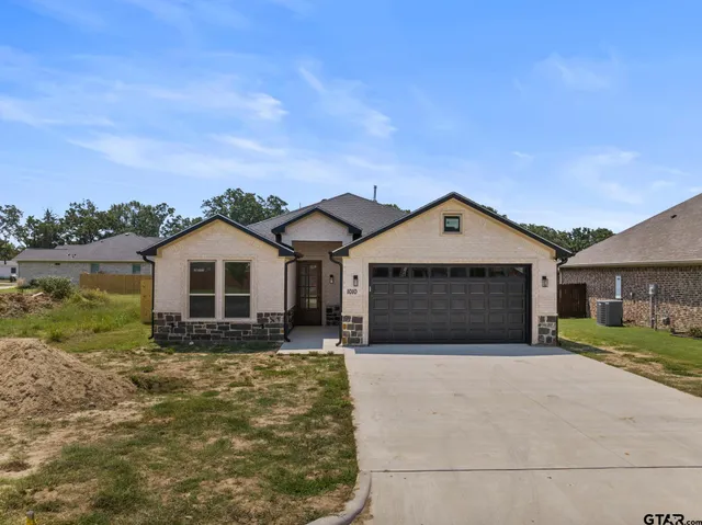 a front view of a house with a yard and garage
