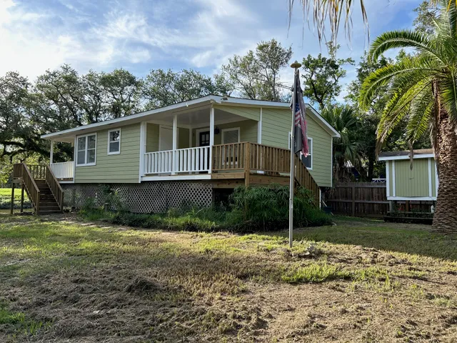 a front view of a house with a yard and potted plants