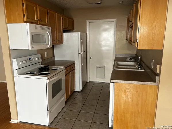 a kitchen with granite countertop a stove and a refrigerator