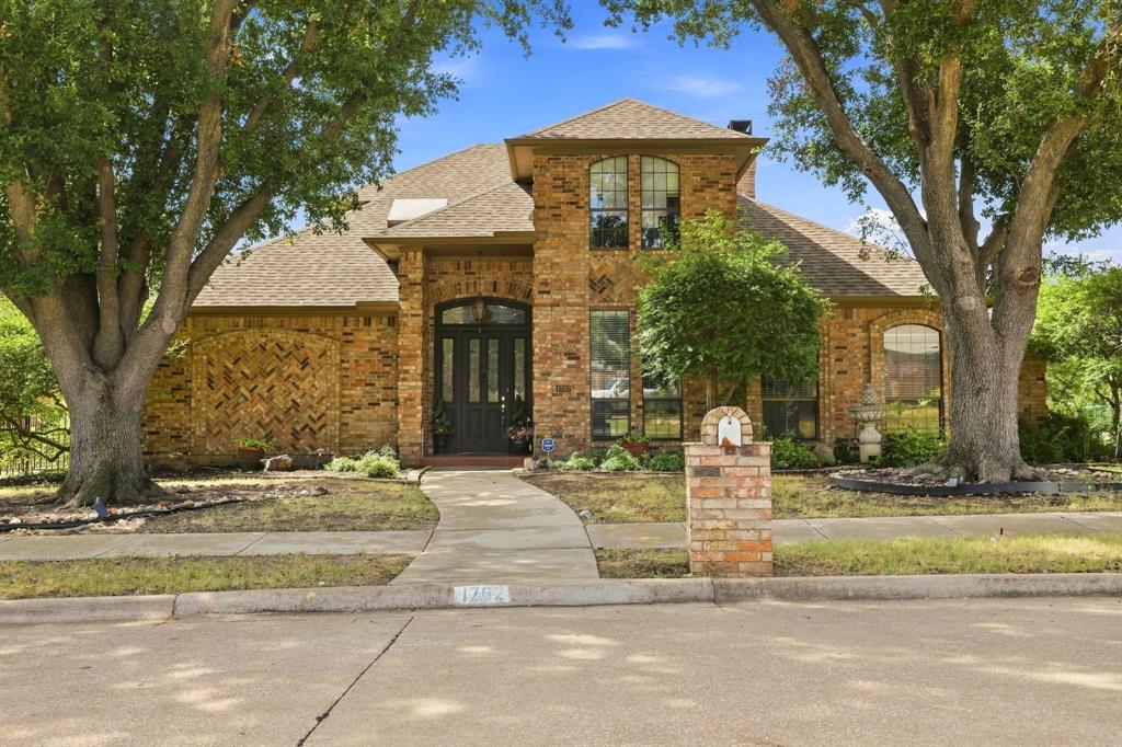1762 Timber Ridge Circle Corinth, TX 76210 - Photo 1 of 29 Brick exterior with arched entry, gabled roofline, and mature trees framing the facade