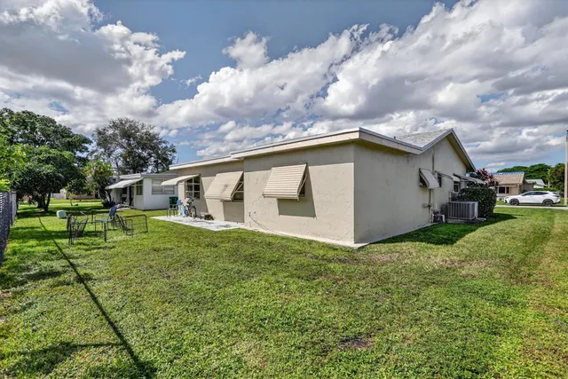 a view of a house with a yard and sitting area