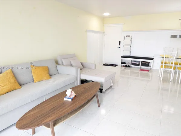 a living room with furniture and kitchen view