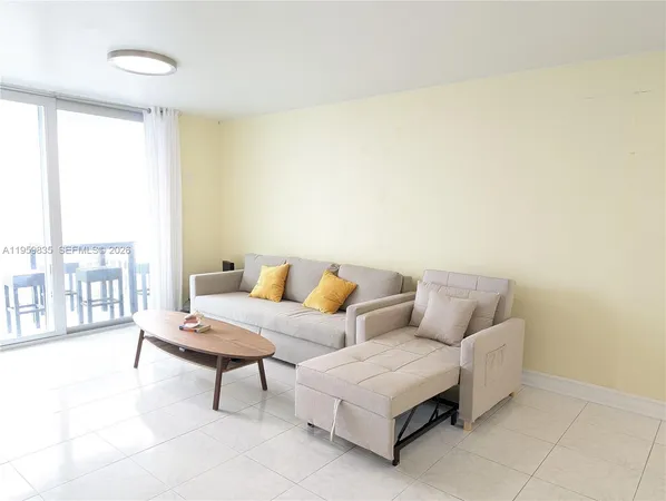 a living room with furniture and a floor to ceiling window