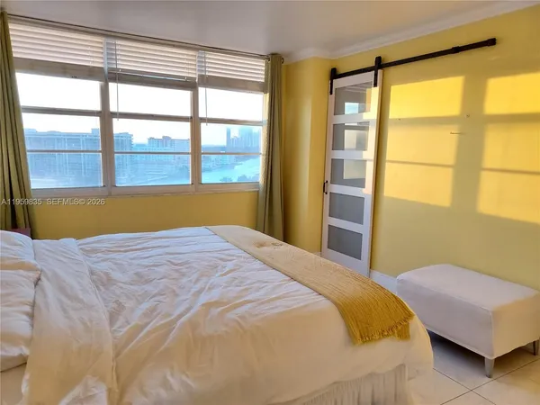 a bedroom with a bed and a large window