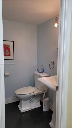 a bathroom with a toilet a sink and mirror