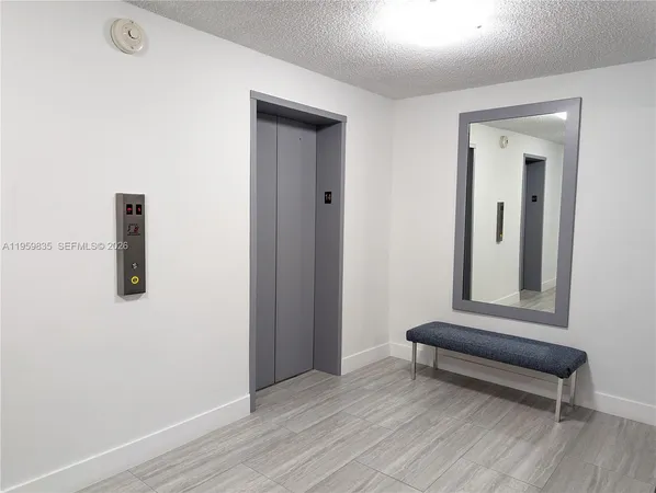 an empty room with wooden floor and mirror