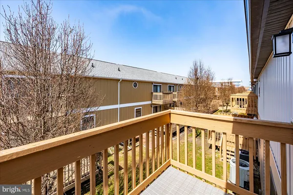 a view of a balcony with wooden floor and fence
