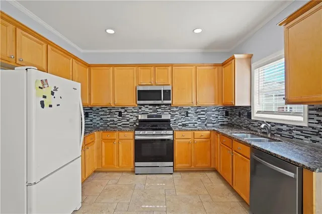 a kitchen with stainless steel appliances granite countertop a stove a sink and a refrigerator