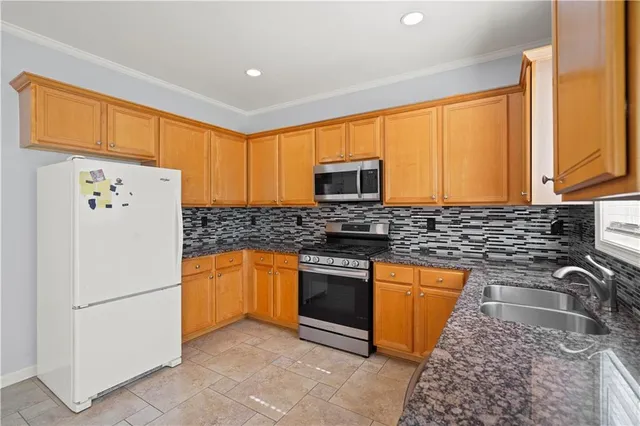 a kitchen with stainless steel appliances granite countertop a refrigerator sink stove microwave and cabinets