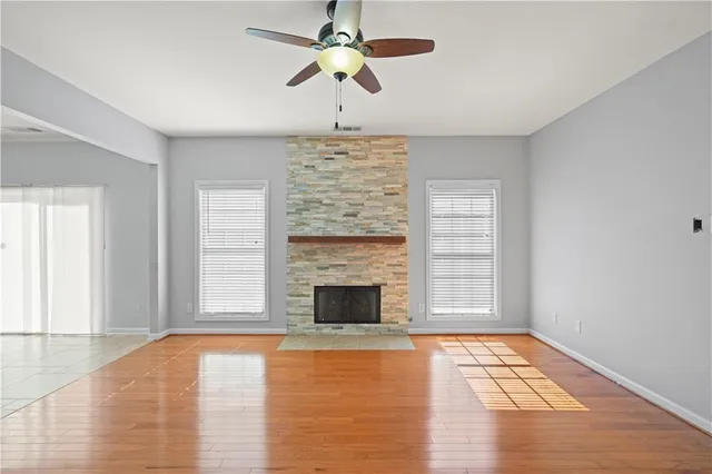 a view of empty room with fireplace and wooden floor