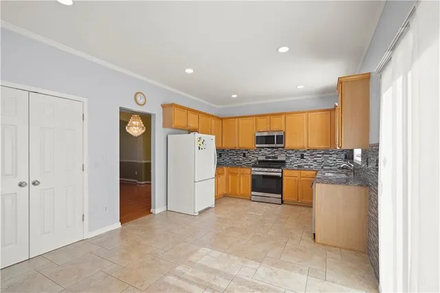 a kitchen with stainless steel appliances granite countertop a refrigerator and a sink