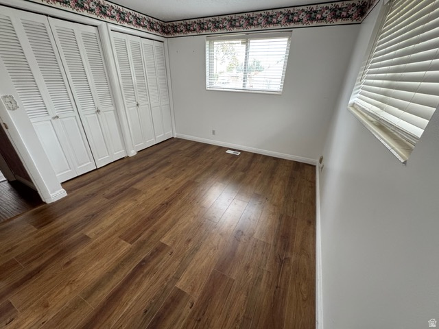 588 North 4500 West West Point, UT 84015 - Photo 19 of 61 Unfurnished bedroom with multiple closets and dark wood finished floors