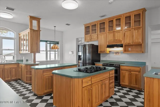 a kitchen with stainless steel appliances granite countertop a sink a stove and a granite counter top