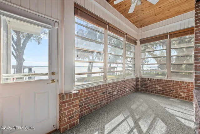 a view of an empty room and chandelier fan