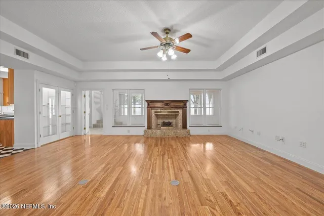 wooden floor fireplace and windows in an empty room
