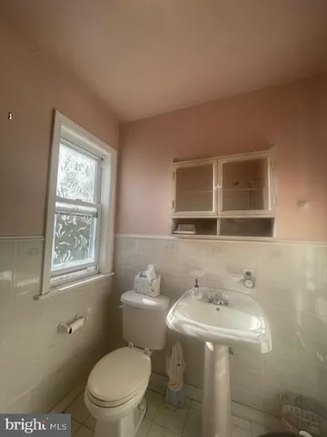 a bathroom with a sink a toilet and mirror