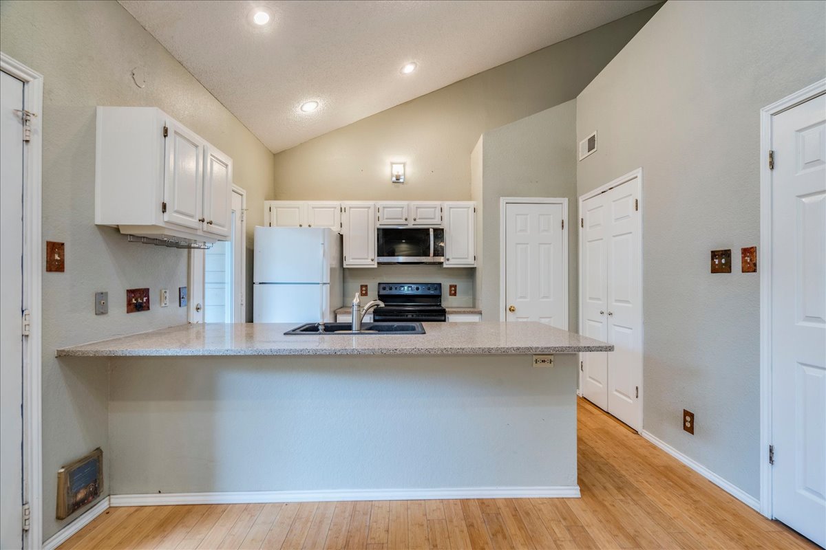 3809 Spicewood Springs Road, Unit 127 Austin, TX 78759 - Photo 9 of 29 A well-equipped kitchen features a functional island with integrated sink, offering ample counter space for culinary endeavors.