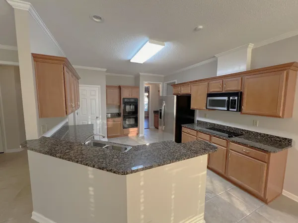 a kitchen with stainless steel appliances granite countertop a sink stove and refrigerator