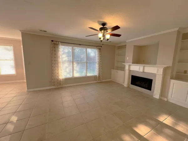 a view of an empty room with a fireplace and a window