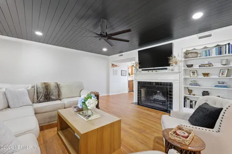 a living room with furniture a fireplace and a flat screen tv