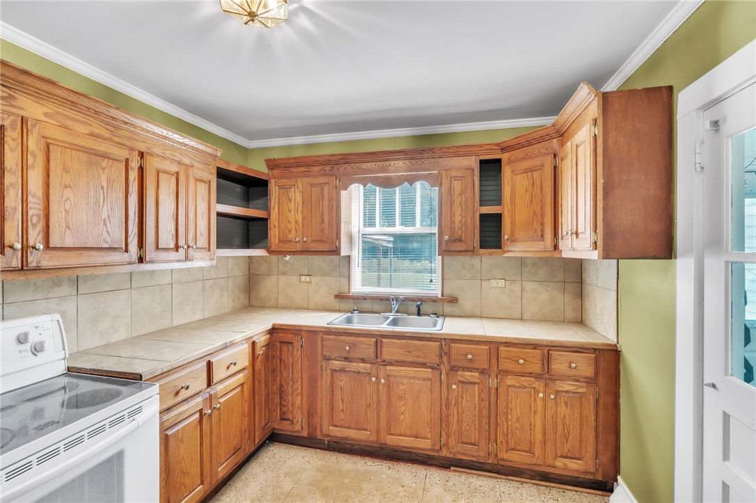 121 Ellison Street Belton, SC 29627 - Photo 7 of 30 This kitchen features classic wood cabinetry and a functional layout, perfect for everyday living.
