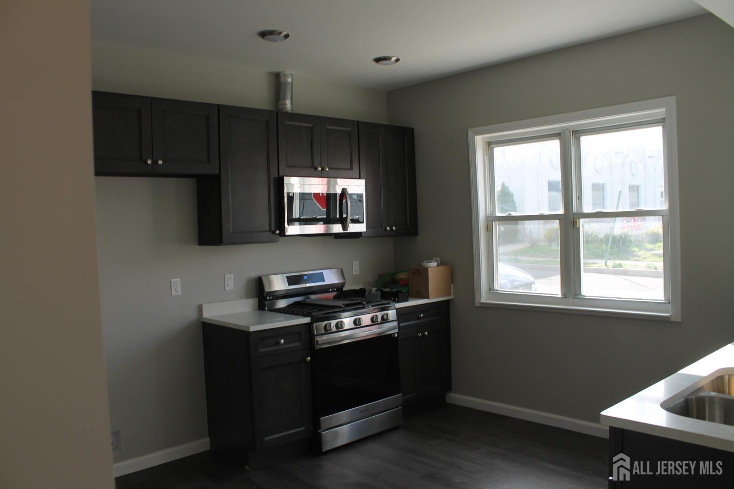 519 Roosevelt Avenue, Unit 2 Carteret, NJ 07008 - Photo 8 of 17 a kitchen with stainless steel appliances a stove a sink and a microwave