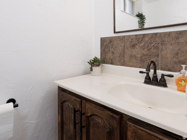 8252 Wood Street Midvale, UT 84047 - Photo 20 of 40 Bathroom vanity with a dark wood-finish cabinet, white countertop, and integrated sink